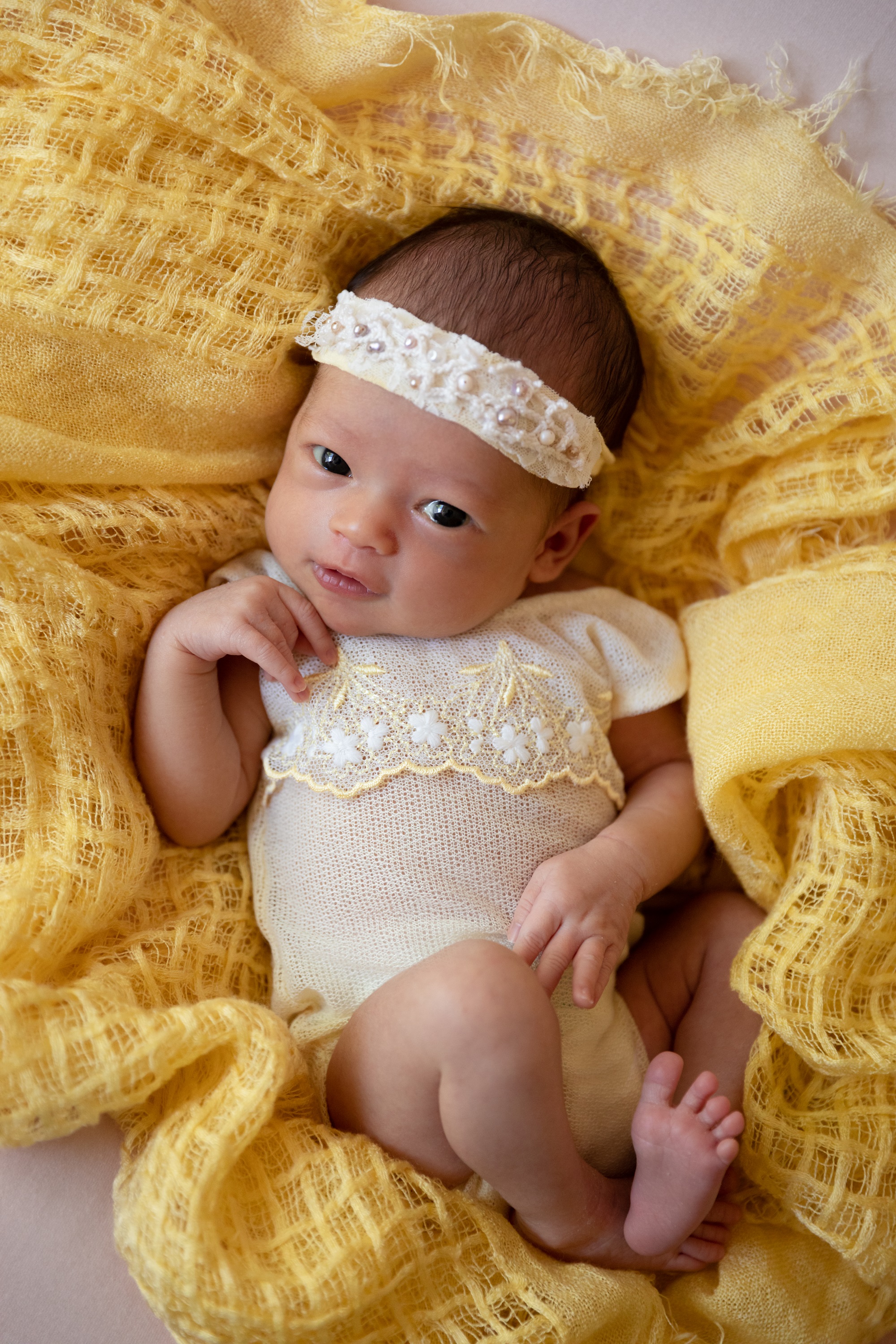 baby girl dressed in yellow vintage newborn outfit