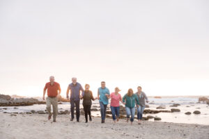 exstended family running on beach at sunset
