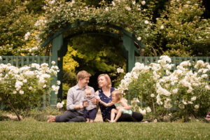 family in rose garden surrounded with white roses